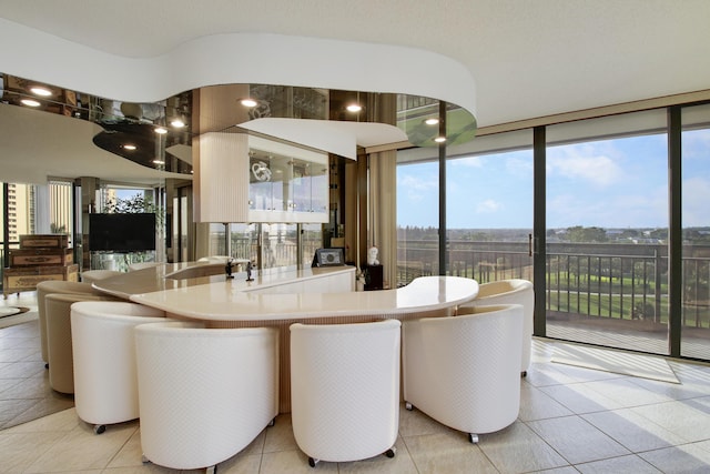 dining area featuring light tile patterned flooring and a wall of windows