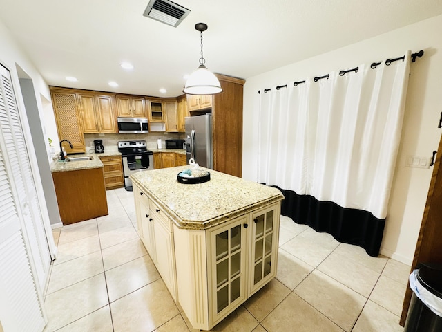 kitchen with stainless steel appliances, sink, pendant lighting, light tile patterned floors, and a center island