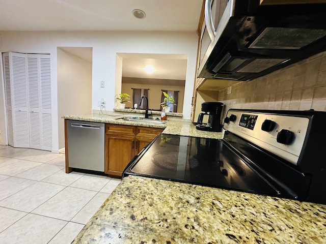 kitchen featuring light stone countertops, sink, light tile patterned floors, dishwasher, and range with electric stovetop