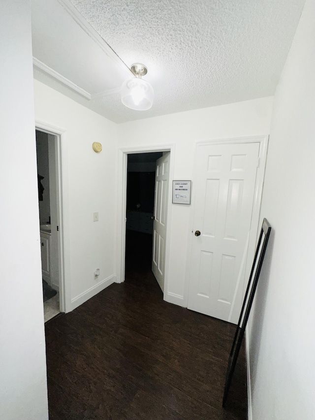 hallway featuring dark hardwood / wood-style floors and a textured ceiling