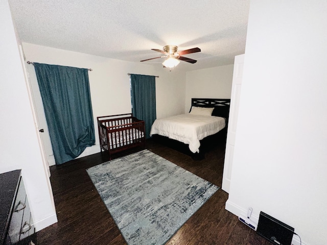 bedroom featuring a textured ceiling, ceiling fan, and dark hardwood / wood-style floors