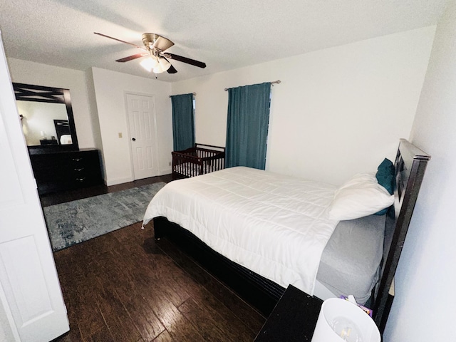 bedroom with ceiling fan, dark hardwood / wood-style floors, and a textured ceiling