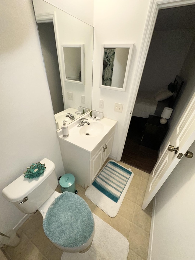 bathroom featuring tile patterned flooring, vanity, and toilet