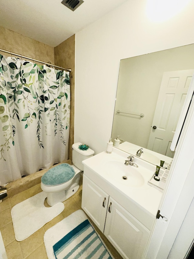 bathroom with tile patterned flooring, vanity, toilet, and walk in shower