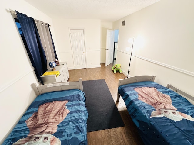 bedroom featuring light hardwood / wood-style floors and a textured ceiling