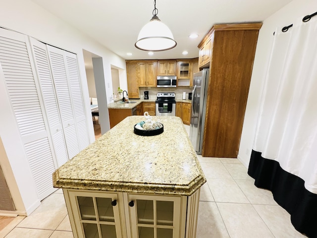 kitchen featuring pendant lighting, light tile patterned flooring, sink, appliances with stainless steel finishes, and a kitchen island