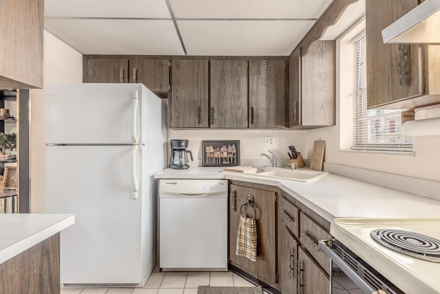 kitchen featuring a paneled ceiling, white appliances, sink, range hood, and light tile patterned flooring