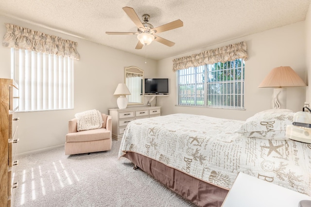 bedroom featuring a textured ceiling, light colored carpet, and ceiling fan