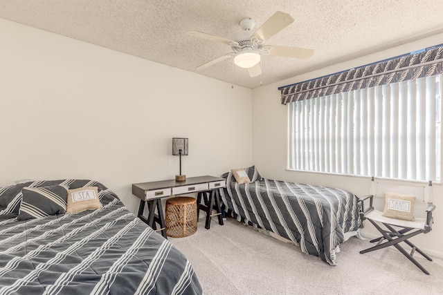 carpeted bedroom featuring ceiling fan and a textured ceiling