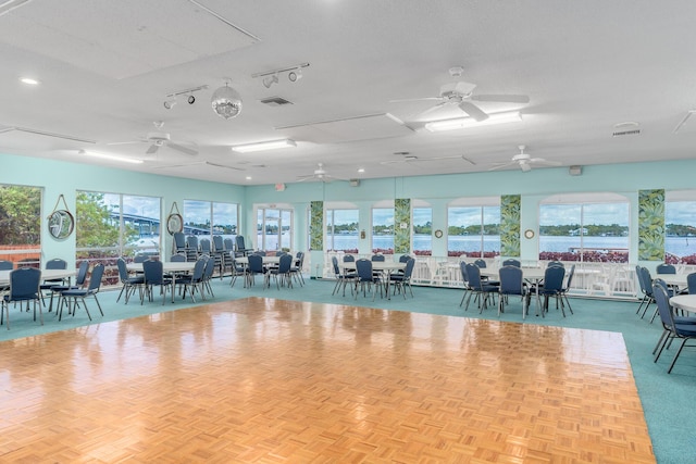 interior space featuring a textured ceiling, plenty of natural light, and ceiling fan