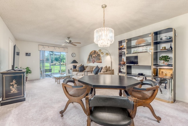 carpeted dining space with a textured ceiling and ceiling fan with notable chandelier