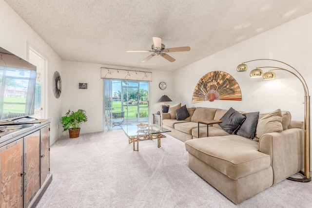 living room featuring ceiling fan, light colored carpet, and a textured ceiling