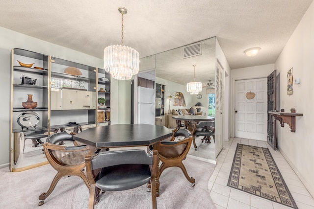 dining space with light tile patterned floors, a textured ceiling, and a notable chandelier