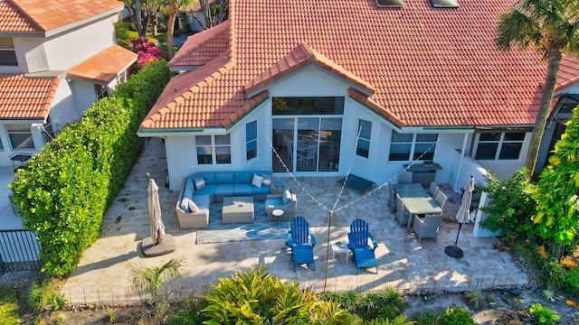 rear view of house featuring a patio area and an outdoor living space