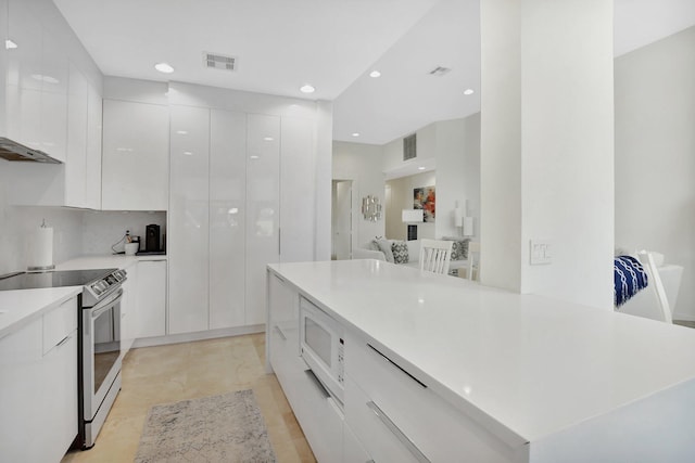 kitchen featuring stainless steel electric stove, white cabinets, light tile patterned floors, tasteful backsplash, and a kitchen island