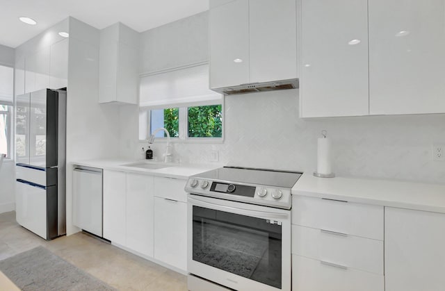 kitchen with sink, light tile patterned floors, ventilation hood, white cabinets, and appliances with stainless steel finishes