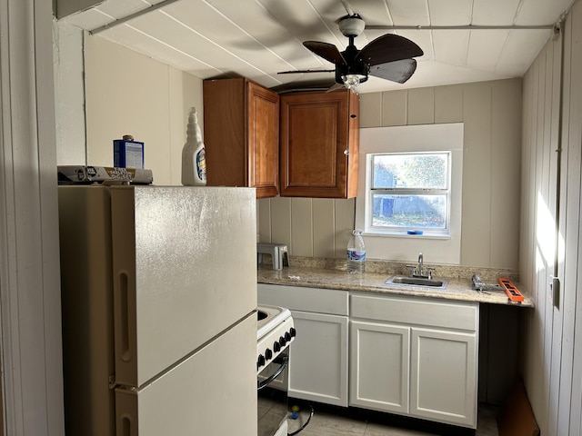 kitchen with ceiling fan, sink, light tile patterned floors, white appliances, and white cabinets