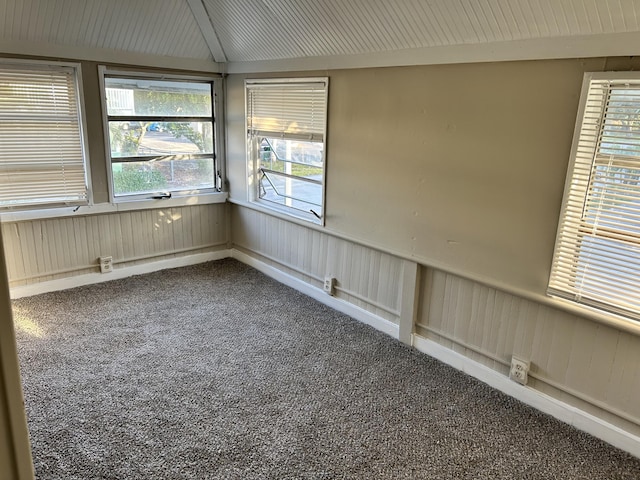 carpeted empty room with vaulted ceiling