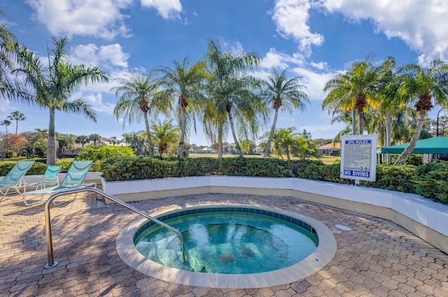 view of swimming pool with a hot tub and a patio area