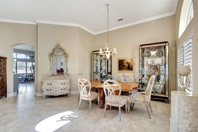 dining room with ornamental molding, a towering ceiling, and a notable chandelier