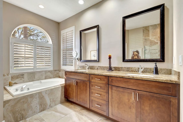 bathroom with vanity and tiled tub