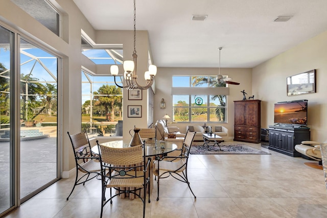 tiled dining space with ceiling fan with notable chandelier