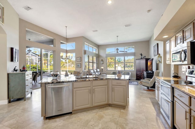 kitchen with hanging light fixtures, a center island, appliances with stainless steel finishes, and sink