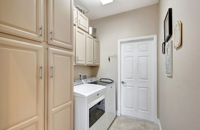 laundry room featuring light tile patterned floors, washing machine and dryer, and cabinets