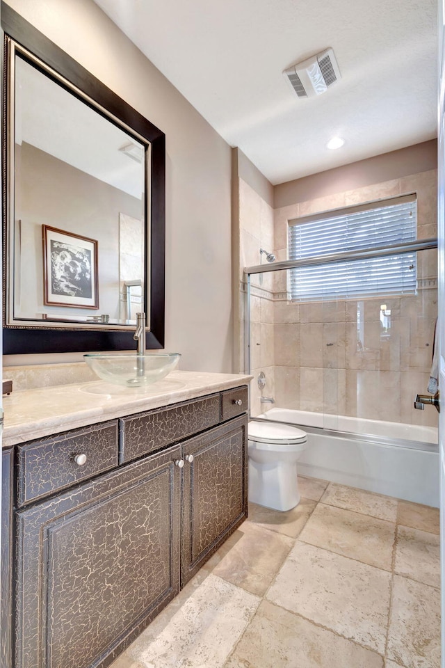 1935 SW Whitemarsh Way, Palm City, FL 34990 - full bathroom featuring vanity, toilet, enclosed tub / shower combo, and stone tile flooring
