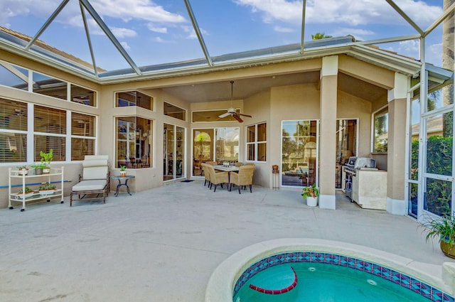 rear view of house with area for grilling, a patio, ceiling fan, and glass enclosure