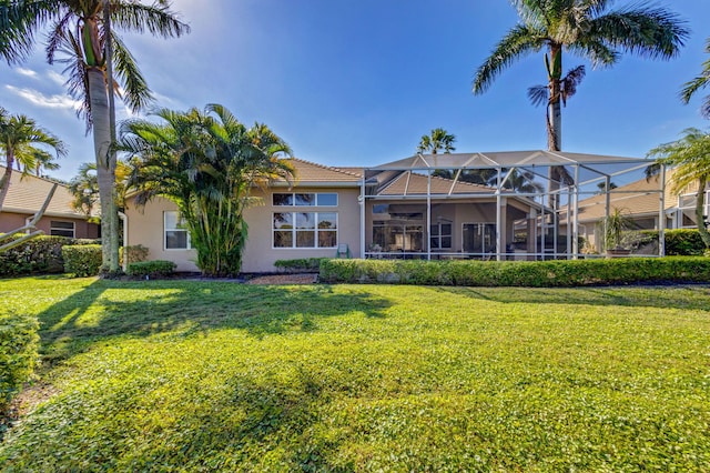 back of house with a lanai and a lawn