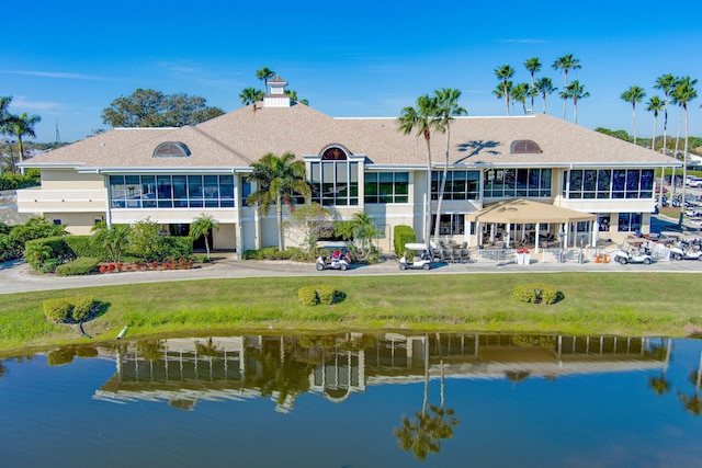 rear view of property with a water view and a lawn