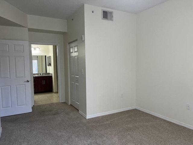 carpeted empty room featuring plenty of natural light and sink