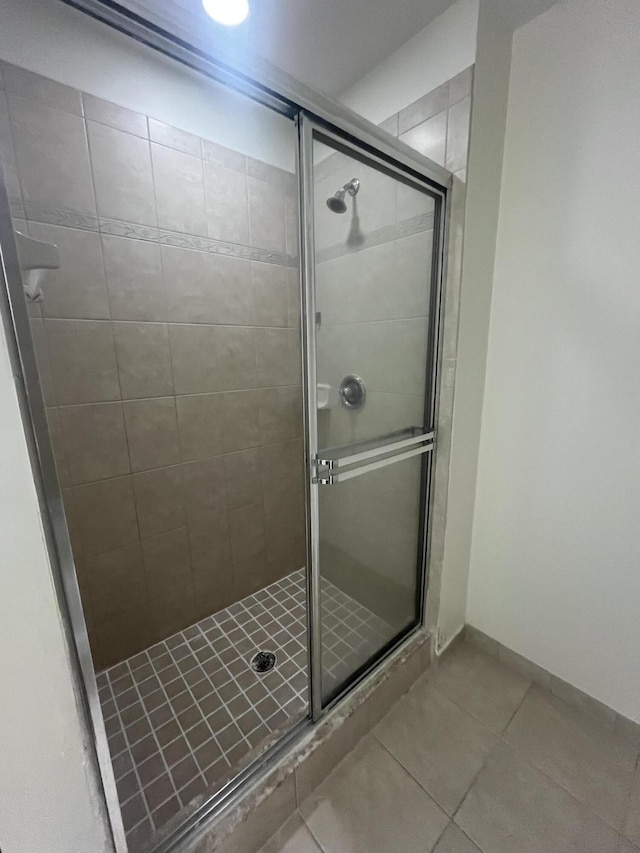 bathroom featuring tile patterned flooring and a shower with shower door