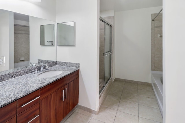 full bathroom with tiled shower, tile patterned flooring, vanity, and baseboards