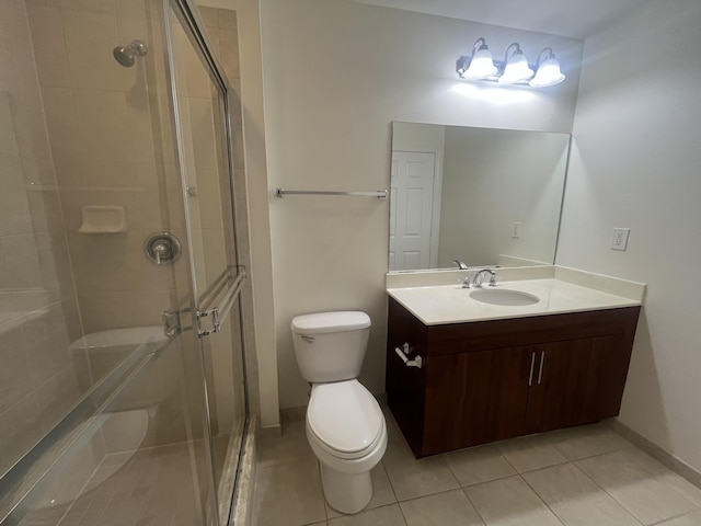 bathroom with tile patterned flooring, vanity, toilet, and walk in shower