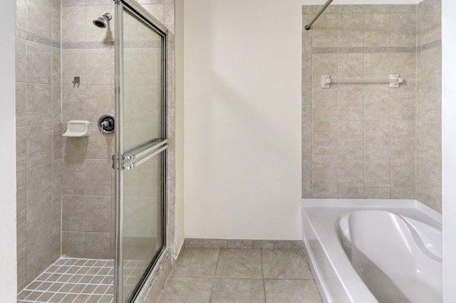 bathroom with a garden tub, a shower stall, and tile patterned floors