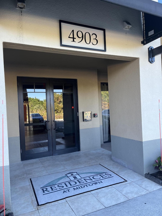 entrance to property with french doors and stucco siding