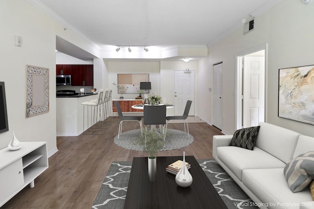 living room with ornamental molding, visible vents, baseboards, and wood finished floors