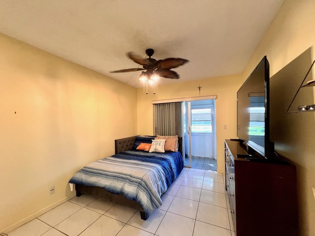 tiled bedroom featuring ceiling fan and a textured ceiling