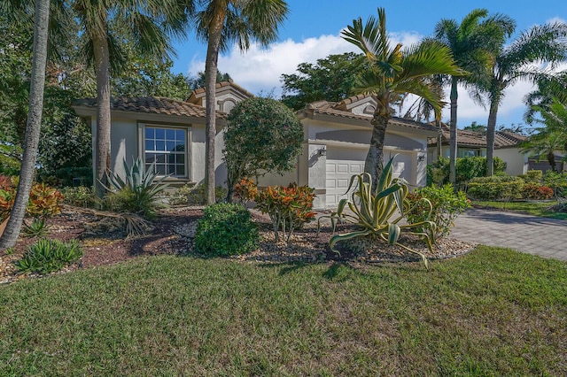 mediterranean / spanish house with a front yard and a garage