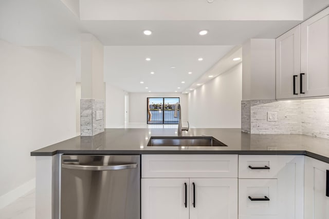 kitchen featuring dishwasher, sink, backsplash, kitchen peninsula, and white cabinets