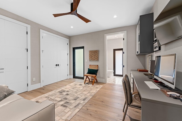 home office with ceiling fan and light wood-type flooring