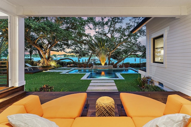 patio terrace at dusk featuring a lawn