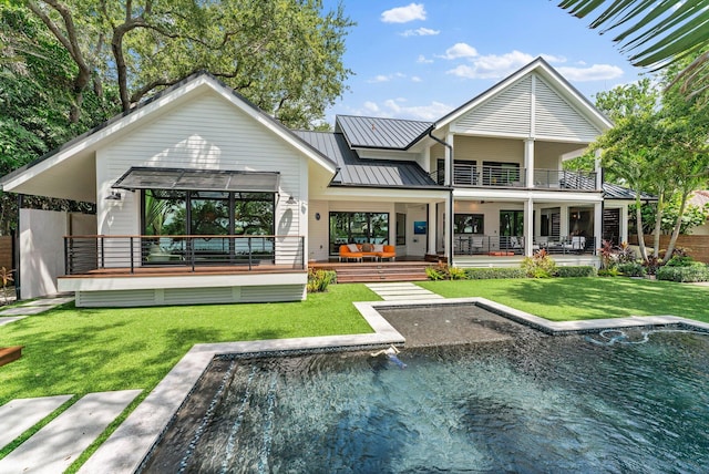 rear view of property featuring a lawn, a balcony, an outdoor hangout area, and a patio