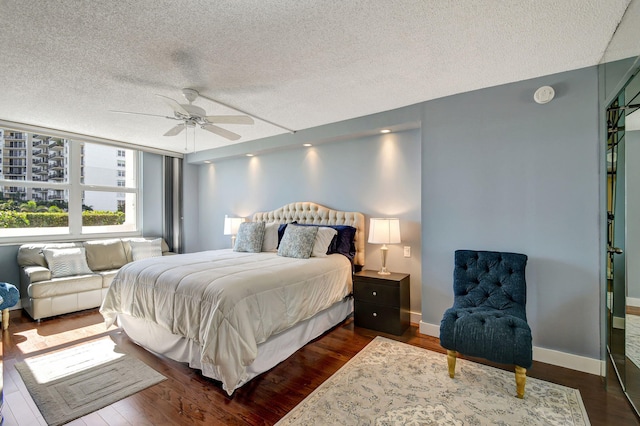 bedroom featuring a textured ceiling, ceiling fan, and dark hardwood / wood-style floors