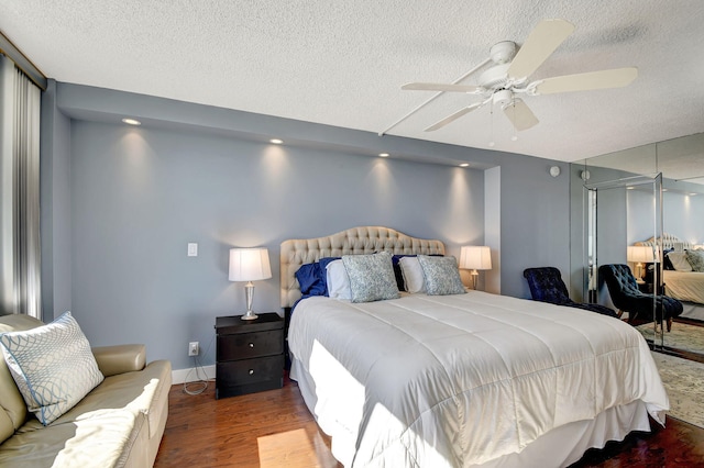 bedroom with ceiling fan, wood-type flooring, and a textured ceiling