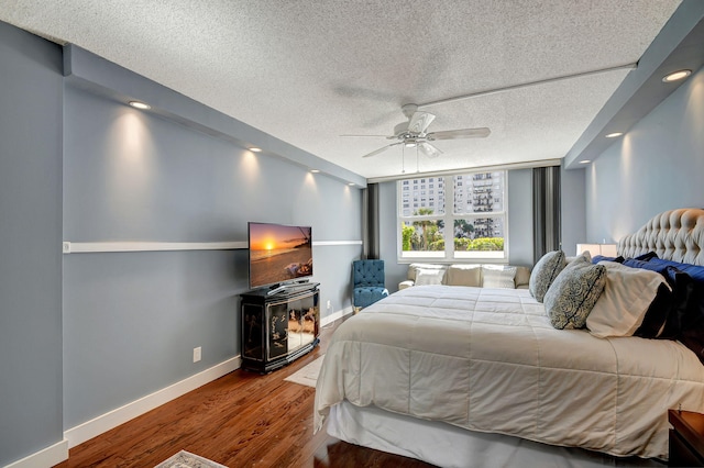 bedroom with wood-type flooring, a textured ceiling, and ceiling fan