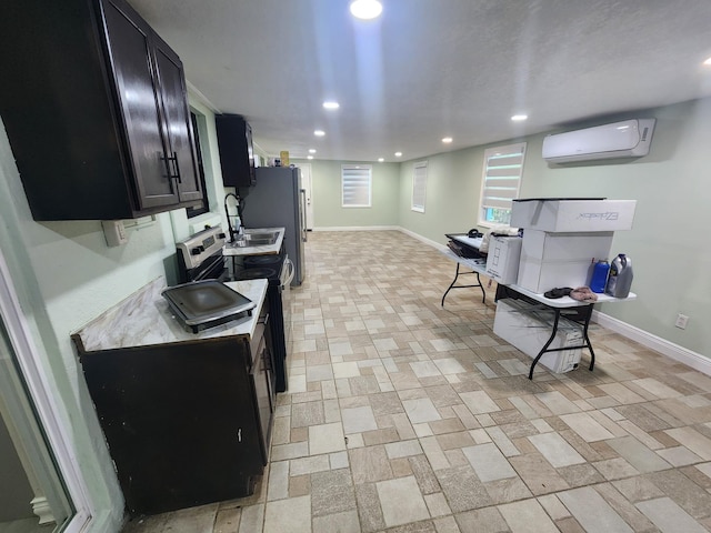 kitchen featuring white refrigerator, a wall mounted AC, and stainless steel electric range