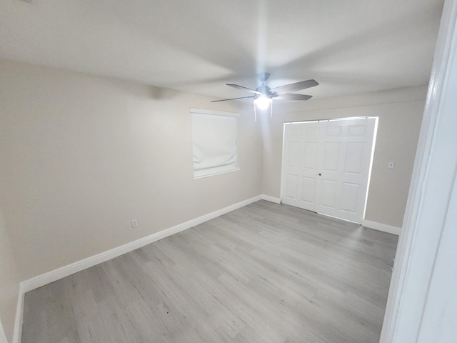 unfurnished bedroom featuring ceiling fan, light hardwood / wood-style floors, and a closet